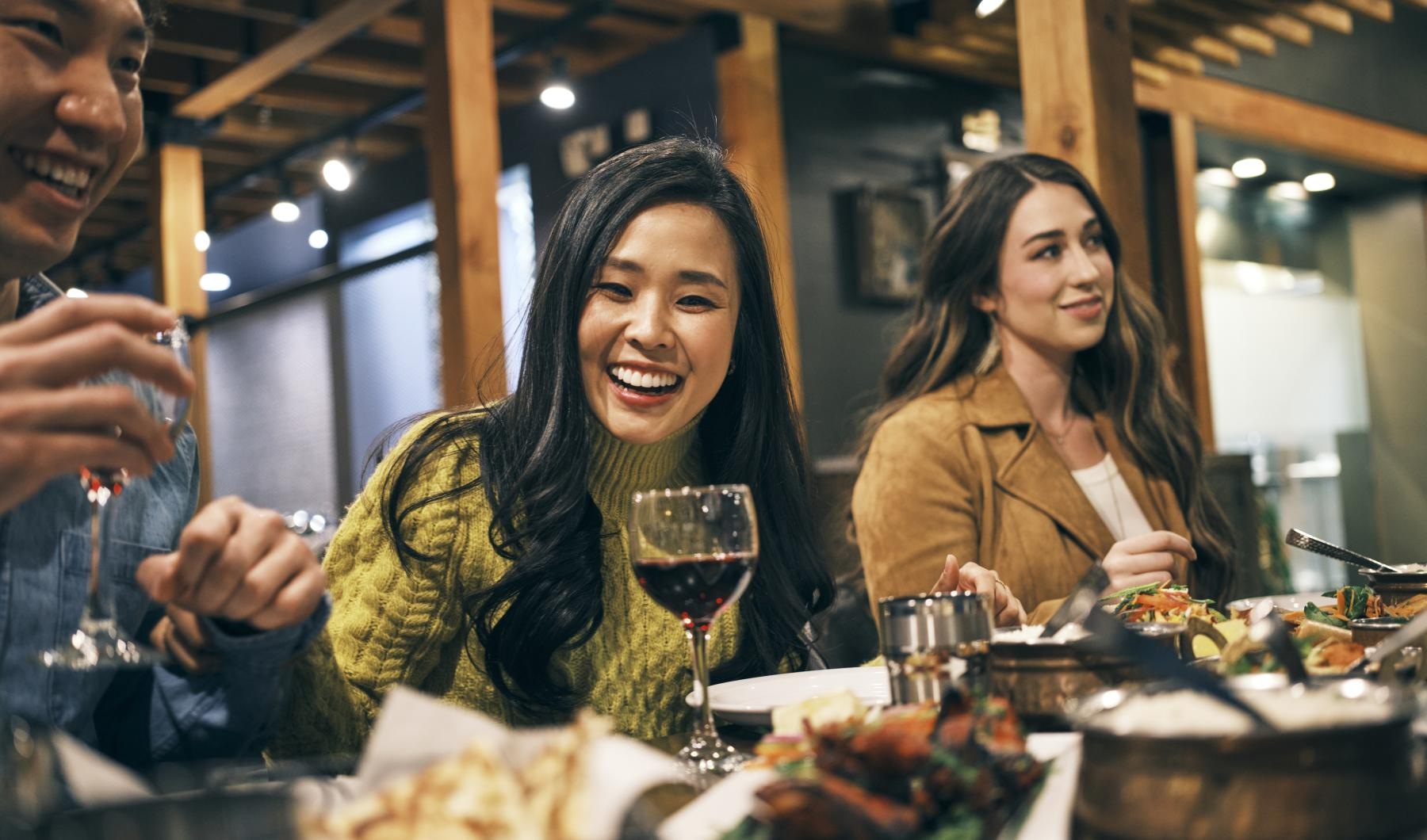 a group of people sitting at a table with food and drinks